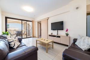 a living room with a couch and a tv at Blue Serenity Complex in Larnaca