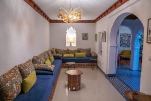 Lalla Ghayta في شفشاون: غرفة معيشة مع أريكة وطاولة