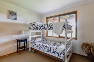 a bedroom with two bunk beds and a window at Prom Beach House in Sandy Point