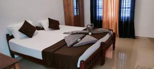 - une chambre avec 2 lits et des serviettes dans l'établissement Le coco beach resort varkala cliff, à Varkala