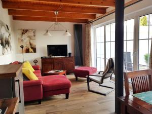 a living room with a red couch and a tv at Inselsonne Haus Inge - Fewo Inge in Breege in Breege