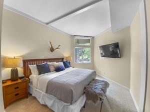 1 dormitorio con 1 cama grande y TV en 24B Powder Run condo, en Park City