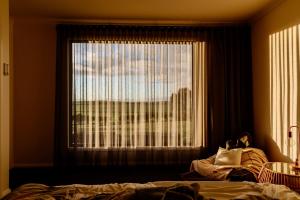 een slaapkamer met een raam met uitzicht op de stad bij Wamoon Retreat Apartment Luxury Gateway to Wilsons Prom in Yanakie