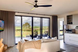 a living room with a couch and a ceiling fan at Wamoon Retreat Apartment Luxury Gateway to Wilsons Prom in Yanakie
