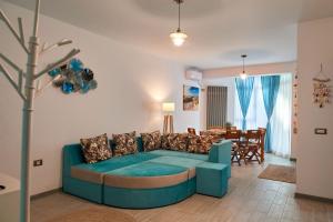 a living room with a blue couch and a dining room at Sea View by Alz in Mamaia Sat/Năvodari