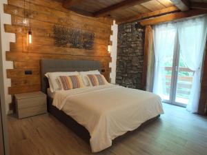 1 dormitorio con 1 cama con pared de piedra en TIVANIA DREAM - Hi-end modern attic, en Zelbio