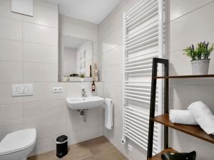 La salle de bains blanche est pourvue d'un lavabo et de toilettes. dans l'établissement INhome Studio Apartment - Küche - Parken - TV, à Schwäbisch Hall
