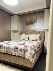 ein Schlafzimmer mit einem Bett mit einer Bettdecke in der Unterkunft Апартамент Девио in Ruse