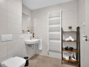 a white bathroom with a sink and a toilet at INhome Studio Apartment - Küche - Parken - TV in Schwäbisch Hall