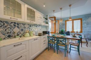 a kitchen with white cabinets and a table and chairs at Pandora Lake View Stresa - Happy Rentals in Stresa