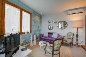 a living room with a purple couch and a tv at Pandora Lake View Stresa - Happy Rentals in Stresa