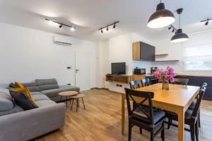 a living room with a table and a couch and a kitchen at Modern holiday house near beach in Fažana