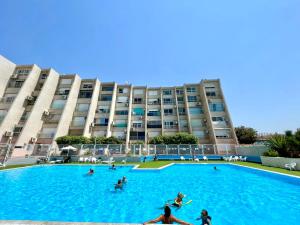 una gran piscina frente a un gran edificio en GW317 Gugel Waves Amazing Seaview Pool Apartments en Nahariyya