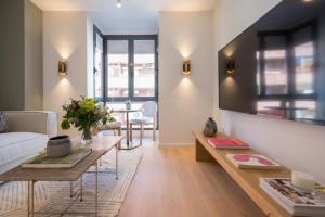 Miosotis Suites في مدريد: غرفة معيشة مع أريكة وطاولة