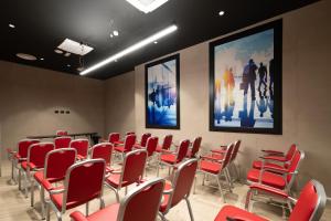 a room with red chairs and posters on the wall at Smart Hotel Central in Milan