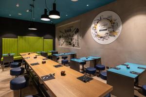 un restaurante con mesas de madera y taburetes azules en Smart Hotel Central, en Milán