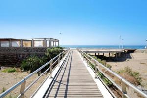 eine Promenade, die zum Strand mit einem Pier führt in der Unterkunft Villa Hyc Playa de las burras in Maspalomas