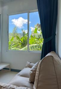 a bedroom with a window and a bed with a view at BAOBAB in Patong Beach