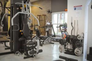a gym with several exercise equipment in a room at Lindo studio equipado em apartamento clube com piscina aquecida e academia no centro de Curitiba - MID Home in Curitiba