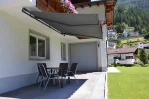 a table and chairs on the side of a house at Ferienwohnung Tanja inklusive Sommercard in Jerzens