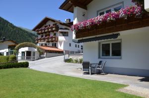 a house with a balcony with flowers on it at Ferienwohnung Tanja inklusive Sommercard in Jerzens