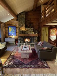 a living room with a stone fireplace in a log cabin at Solsetra - Mountain Majesty Family Log Cabin in Hovden