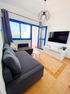 un soggiorno con divano e TV a schermo piatto di Casa Sol y Mar a Costa Calma