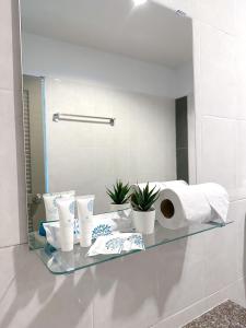 a glass shelf in a bathroom with toilet paper and a mirror at BAOBAB in Patong Beach