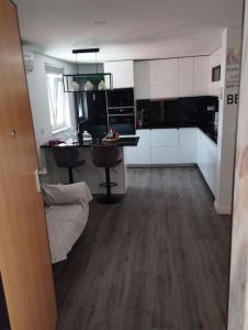 a kitchen with white cabinets and a wooden floor at Katyto house in Costa da Caparica +20 photos