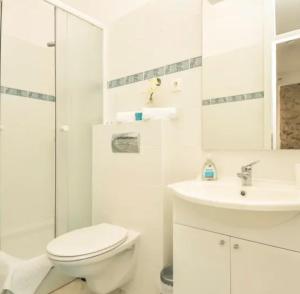 La salle de bains blanche est pourvue de toilettes et d'un lavabo. dans l'établissement DreamWorksApartments-1, à Karlobag