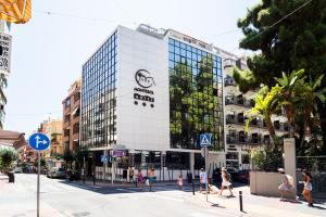 a tall white building with people walking in front of it at Hotel Montesol Benidorm in Benidorm