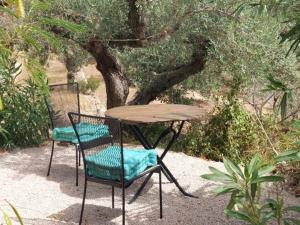 una mesa y dos sillas sentadas junto a un árbol en Casita Bella Vida, en L'Ampolla