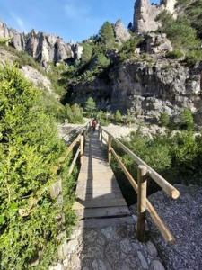 uma ponte de madeira sobre uma montanha com pessoas andando sobre ela em Casita Bella Vida em L'Ampolla
