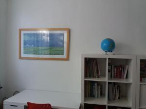 un estante de libros blanco con una foto en la pared en family house, free parking, 15min. walk to city en Brujas