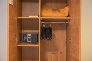 a wooden cabinet with a microwave in it at Hotel Eder in Munich