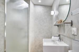 a bathroom with a sink and a mirror at Originals Boutique, Hôtel Larivaut, Puy-Guillaume in Puy-Guillaume