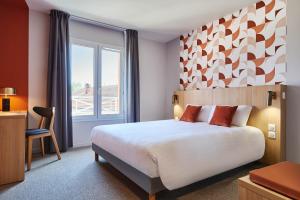 a hotel room with a large bed and a window at Originals Boutique, Hôtel Larivaut, Puy-Guillaume in Puy-Guillaume