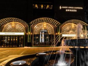 een fontein voor een gebouw 's nachts bij Guangzhou Tianhe Taikoohui - Coffee Rupin Hotel,Canton Fair Free Shuttle Bus in Guangzhou