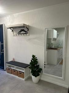 a mirror in a room with a bench and a kitchen at Apartment am Deister in Barsinghausen