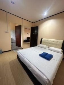Kampong Kundassan的住宿－Ren-Hana Kundasang，卧室配有带蓝色枕头的大型白色床