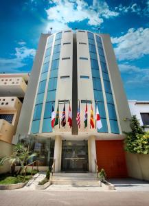 a building with several flags in front of it at Embajadores Hotel in Lima