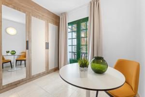 Una mesa blanca con un jarrón en una habitación en Apartamentos Tropicana, en Puerto del Carmen