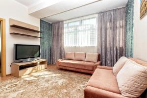 uma sala de estar com um sofá e uma televisão em Жк Нурсая вблизи Байтерека em Astana