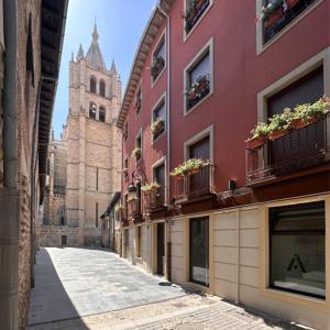 una calle vacía con un edificio y una iglesia en HOSTEL ALEA, en León
