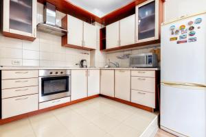 uma cozinha com armários brancos e um frigorífico em Жк Нурсая вблизи Байтерека em Astana