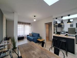 a living room with a blue couch and a kitchen at Manhattan, Appartement calme in Reims