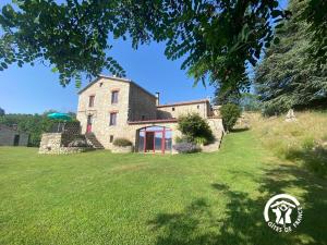 una casa su una collina con un prato di MAS LO BOACH a Saint-Laurent-de-Cerdans