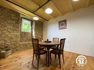 una sala da pranzo con tavolo e sedie in legno di MAS LO BOACH a Saint-Laurent-de-Cerdans Altre 11 foto