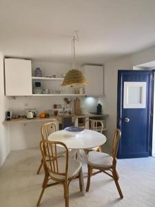 a kitchen with a table and chairs and a blue door at Casa Buganvilla in Alcácer do Sal