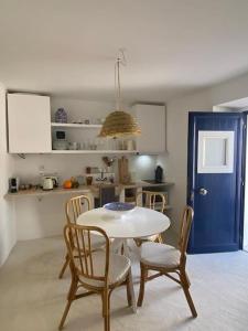 a kitchen with a table and chairs and a blue door at Casa Buganvilla in Alcácer do Sal +20 photos